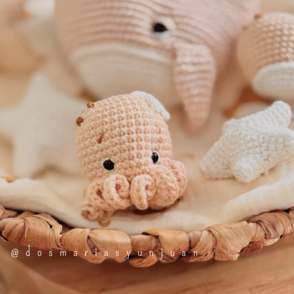 Small crochet octopus held in hands – amigurumi pattern by Dos Marías y un Juan