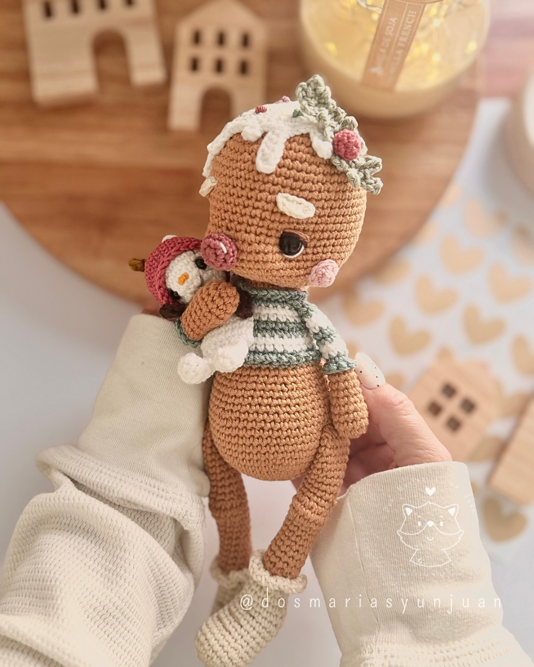 Candito gingerbread amigurumi shown in hands, wearing striped sweater and frosting details.